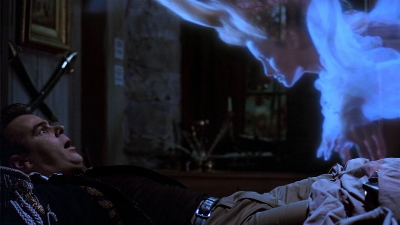 A lady ghost floats over Dan Aykroyd in Ghostbusters