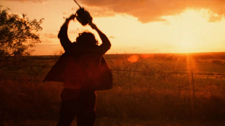 Leatherface holding up a chainsaw at sunset in Texas Chain Saw Massacre